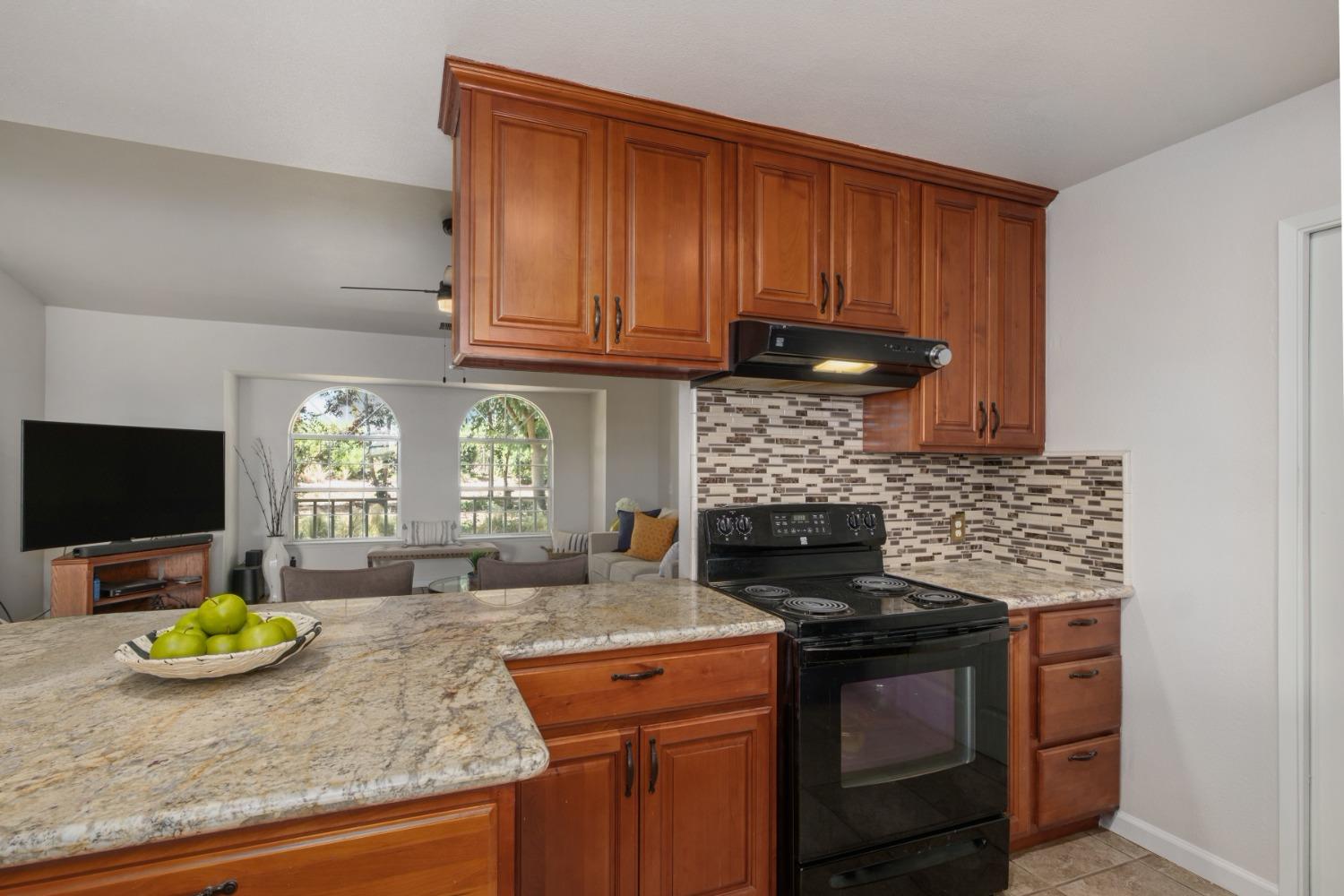 29001 Ave 22 Madera, CA 93638 - Photo 7 of 31 a kitchen with granite countertop stainless steel appliances a stove a sink and a microwave