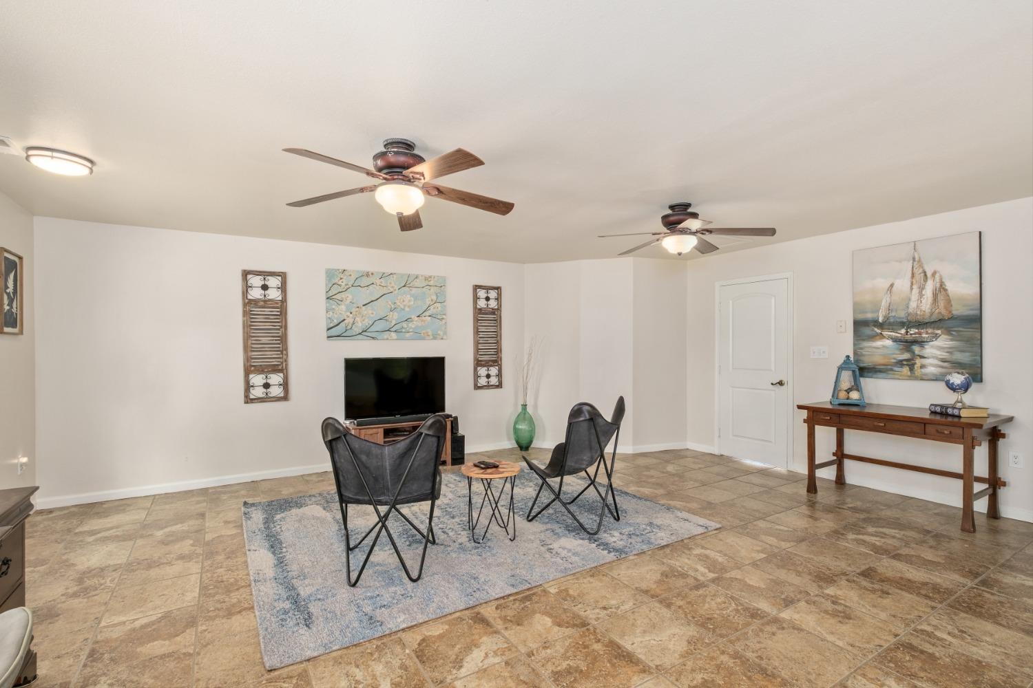 29001 Ave 22 Madera, CA 93638 - Photo 10 of 31 a living room with furniture a fireplace and a chandelier
