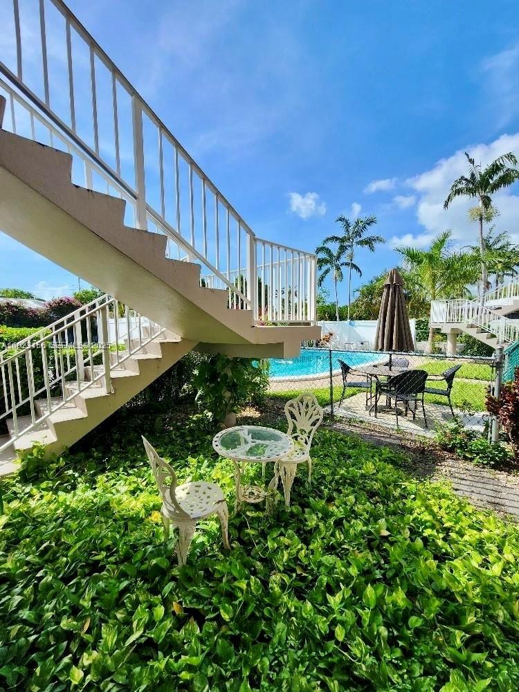 2665 Middle River Drive, Unit 7 Fort Lauderdale, FL 33306 - Photo 7 of 8 a view of a swimming pool with lawn chairs and plants