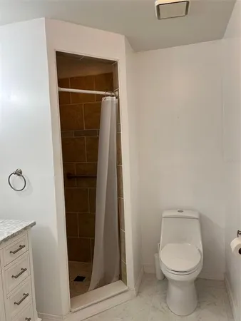 a bathroom with a toilet and a shower