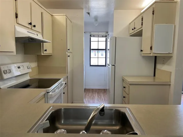 a kitchen with a sink a stove and cabinets