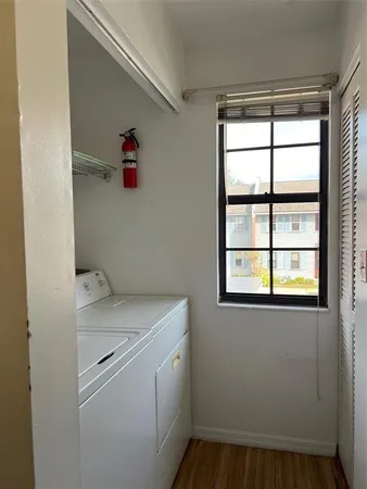 a utility room with dryer and window