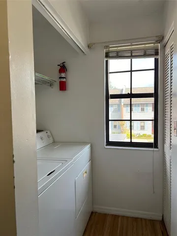 a utility room with dryer and window