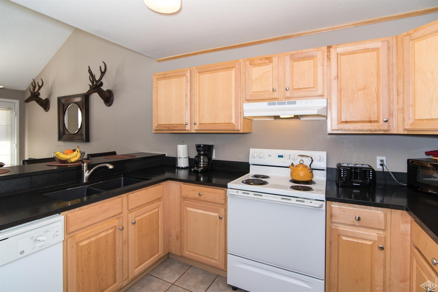 3901 Big Horn Road, Unit 2H Vail, CO 81657 - Photo 8 of 16 a kitchen with granite countertop a sink and white cabinets