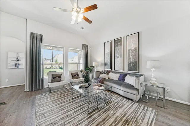 a bedroom with a bed a chair and potted plant on the dresser