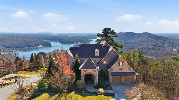 a aerial view of a house with swimming pool and mountains in the background