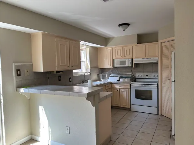 a kitchen with a stove top oven sink and cabinets