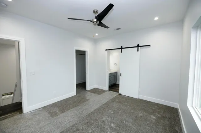 a view of a livingroom with a ceiling fan & entryway