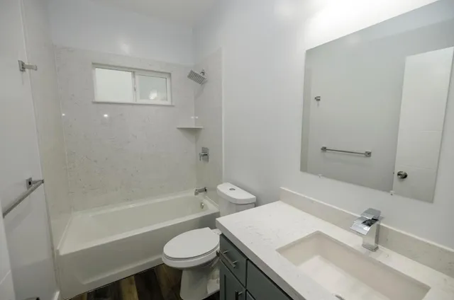 a bathroom with a sink toilet a mirror and shower