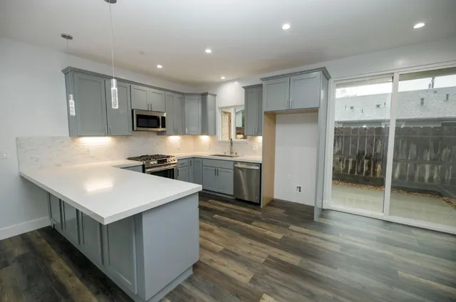 a view of kitchen and hall with wooden floor