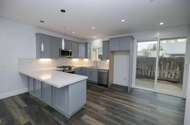 a kitchen with stainless steel appliances granite countertop a sink stove and refrigerator