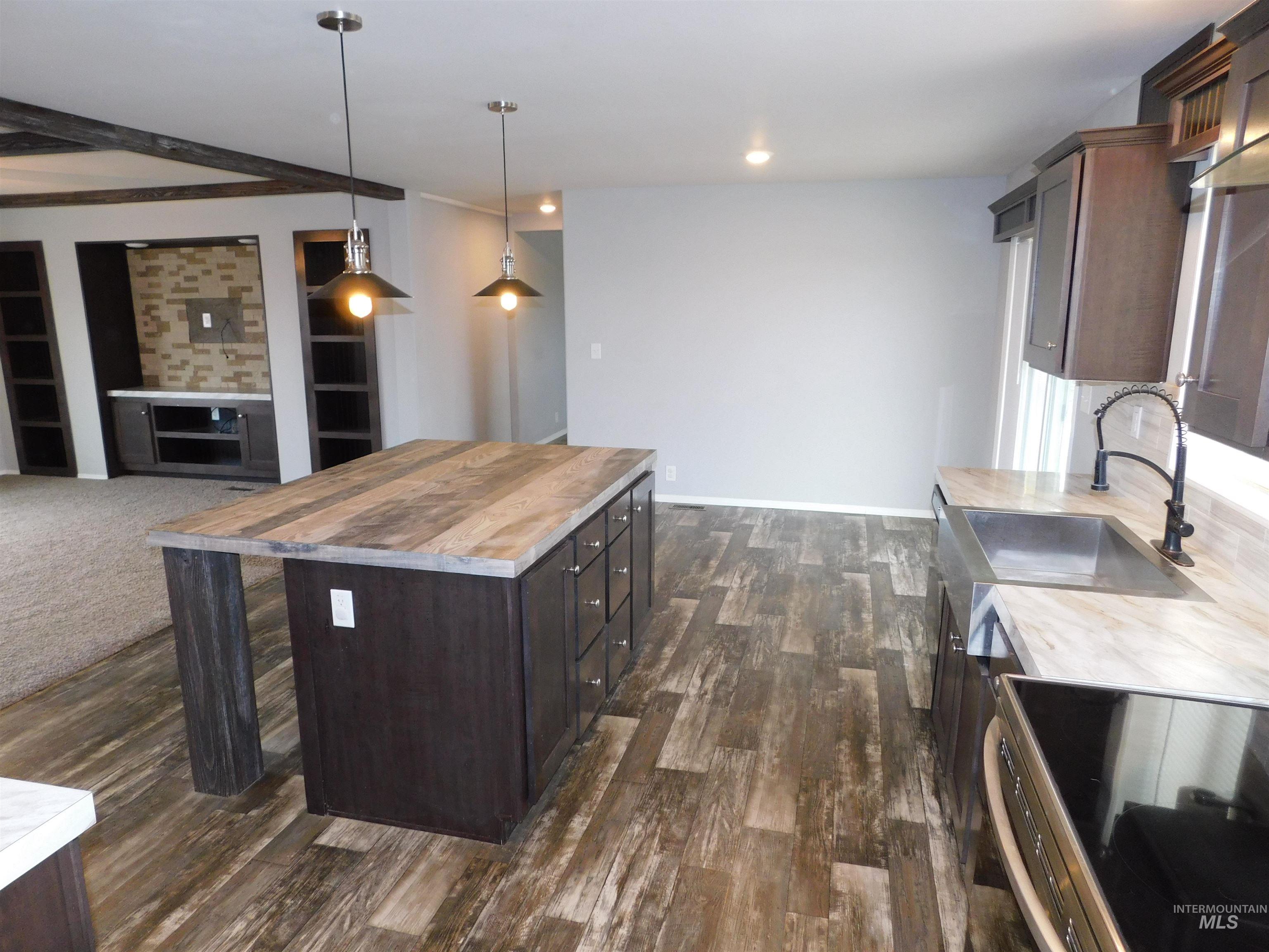 26915 Chips Lane Parma, ID 83660 - Photo 47 of 48 Kitchen featuring dark brown cabinetry, wood counters, decorative light fixtures, stainless steel electric range, and open floor plan