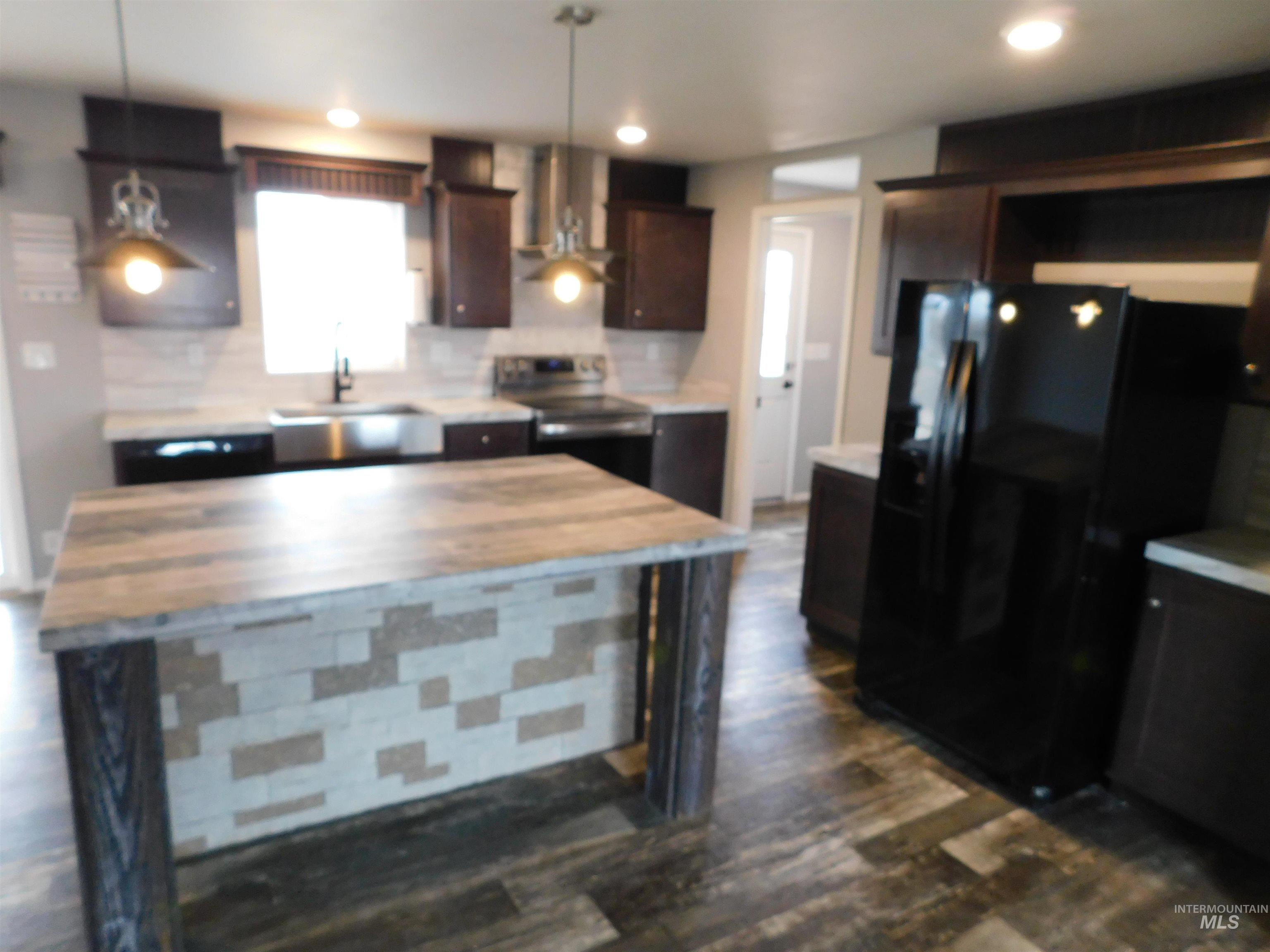 26915 Chips Lane Parma, ID 83660 - Photo 6 of 48 Kitchen featuring black fridge, electric range, range hood, tasteful backsplash, and dark brown cabinetry