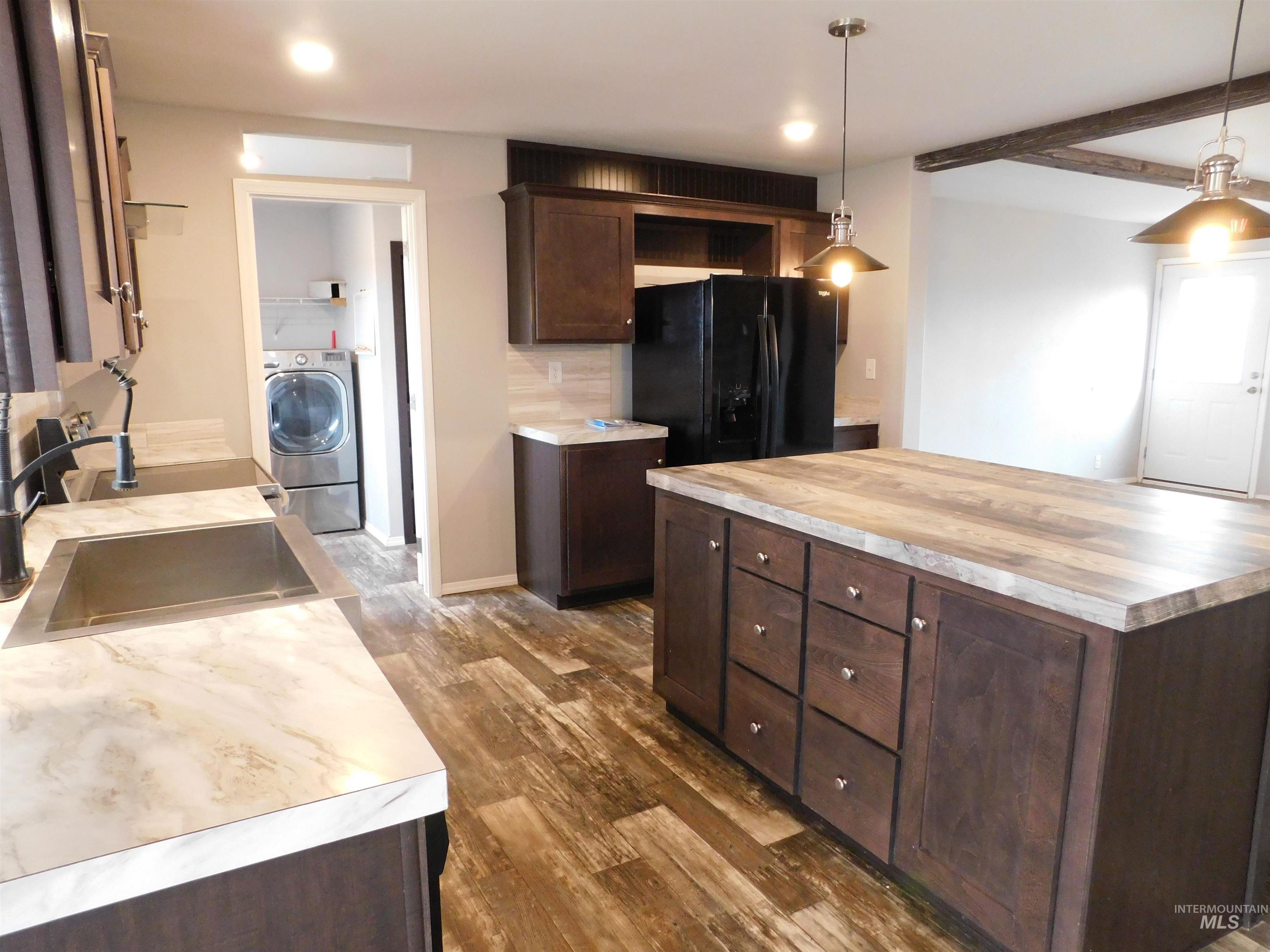 26915 Chips Lane Parma, ID 83660 - Photo 7 of 48 Kitchen featuring dark brown cabinetry, wooden counters, freestanding refrigerator, hanging light fixtures, and dark wood-style floors