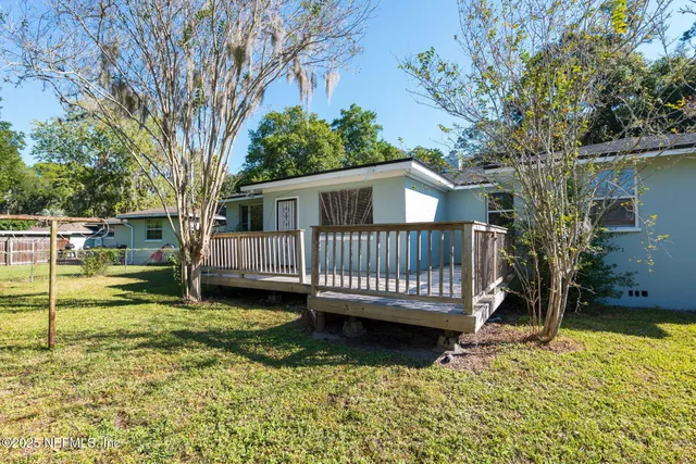 a view of a house with a backyard and a tree