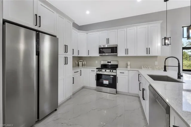 a kitchen with stainless steel appliances a refrigerator sink and cabinets