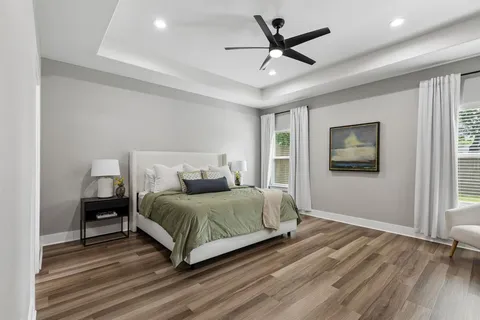 a bedroom with a large bed and a ceiling fan