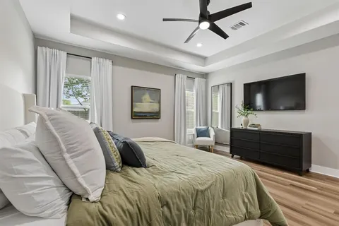 a bedroom with a bed television and a window