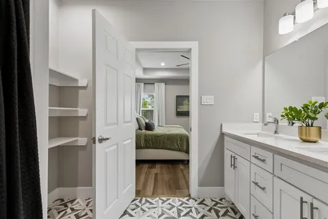 a en suite bathroom with a granite countertop sink and a mirror