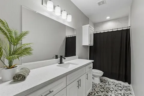 a bathroom with a sink a toilet and a large mirror