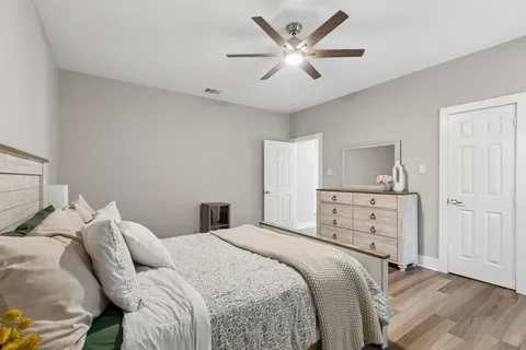 a bedroom with a large bed and a chandelier