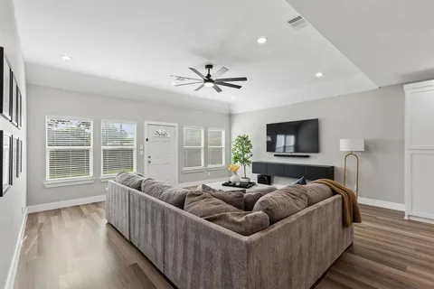a living room with furniture and a flat screen tv with wooden floor
