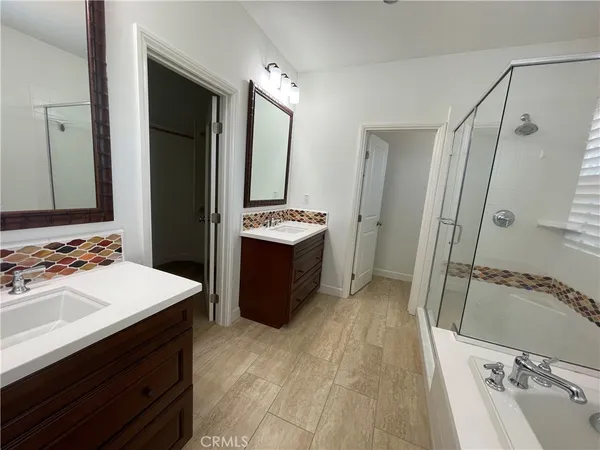 a bath room with a sink vanity tub and a mirror