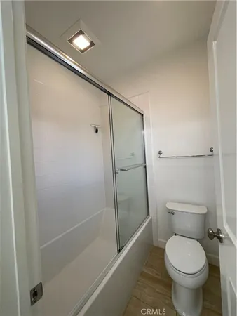 a bathroom with a granite countertop toilet and a shower