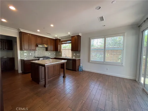 a kitchen with stainless steel appliances granite countertop a stove a sink and a refrigerator