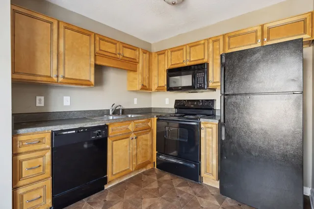a kitchen with stainless steel appliances granite countertop a refrigerator stove top oven a sink and dishwasher