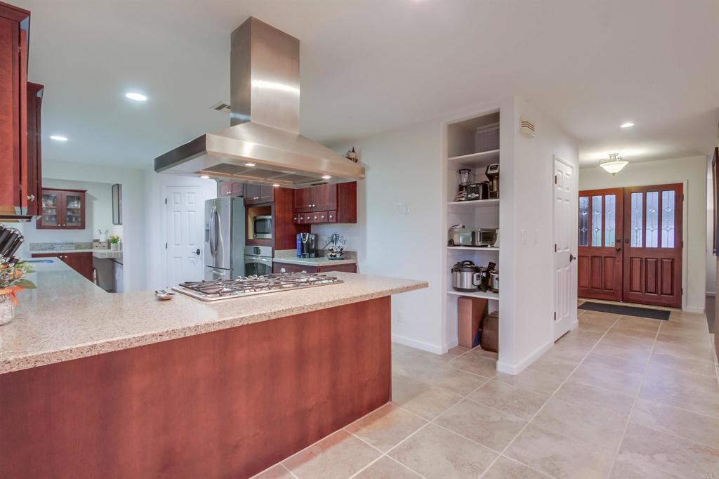 1321 Friends Way Fallbrook, CA 92028 - Photo 12 of 71 a large kitchen with stainless steel appliances a stove a refrigerator a sink dishwasher with a dining table and chairs