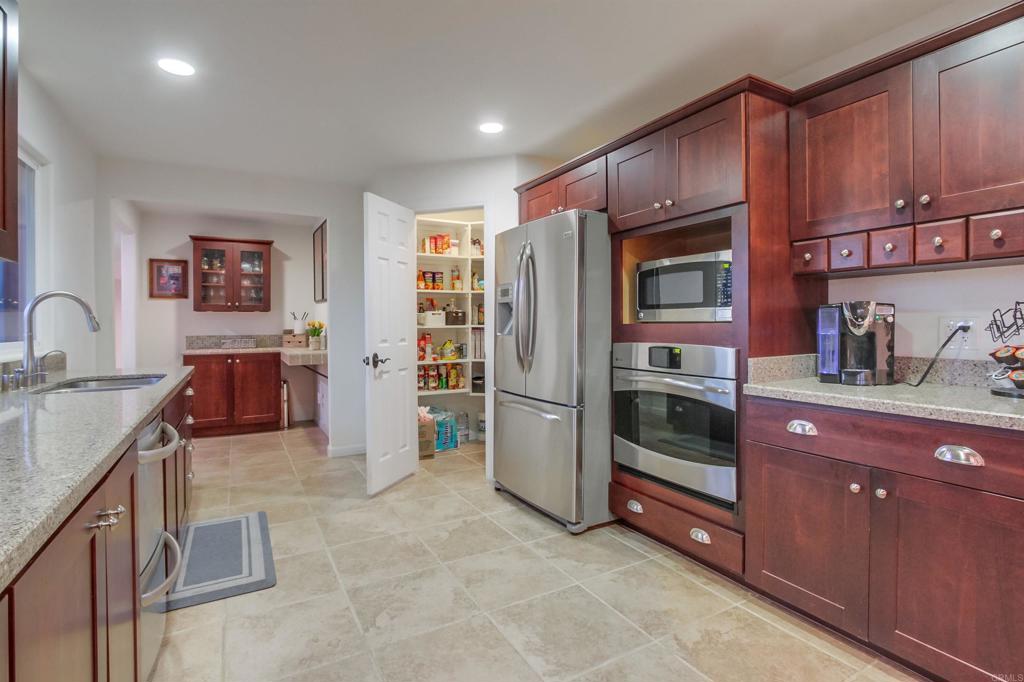 1321 Friends Way Fallbrook, CA 92028 - Photo 15 of 71 a kitchen with stainless steel appliances granite countertop a refrigerator and a sink