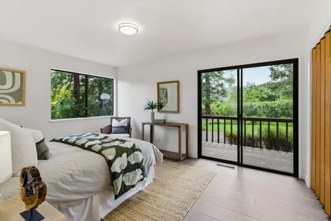 a bedroom with a bed and large windows