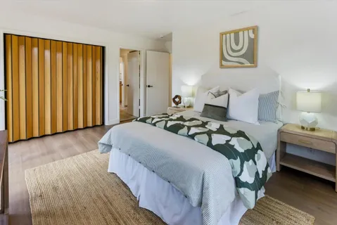 a bedroom with a bed and wooden floor