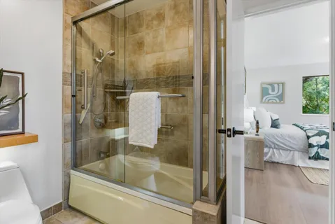 a bathroom with a granite countertop sink mirror and shower