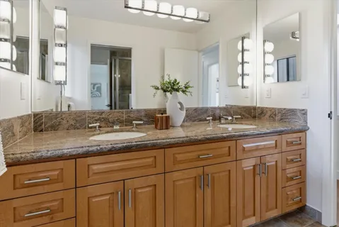a bathroom with double sink and a mirror