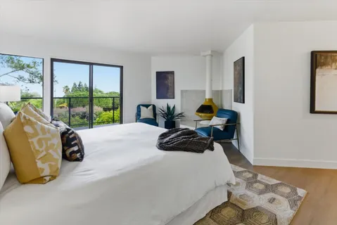 a living room with furniture floor to ceiling window and wooden floor