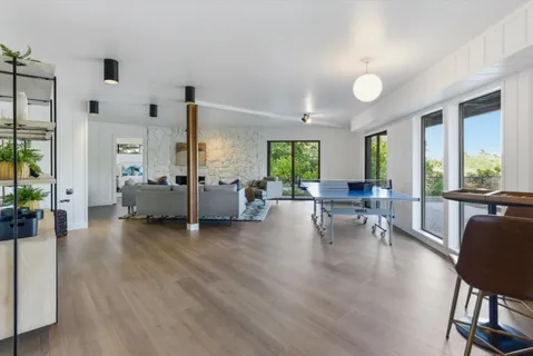 a living room with furniture large windows and a rug