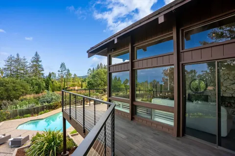 a view of a patio with couches table and chairs with potted plants and big yard