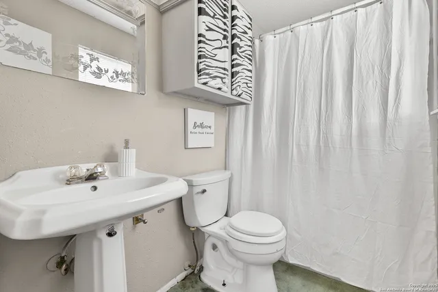 a bathroom with a sink a toilet and a mirror