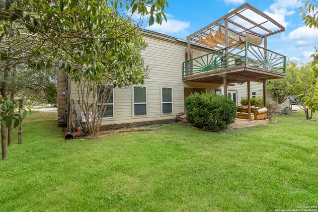 a view of a house with backyard and sitting area