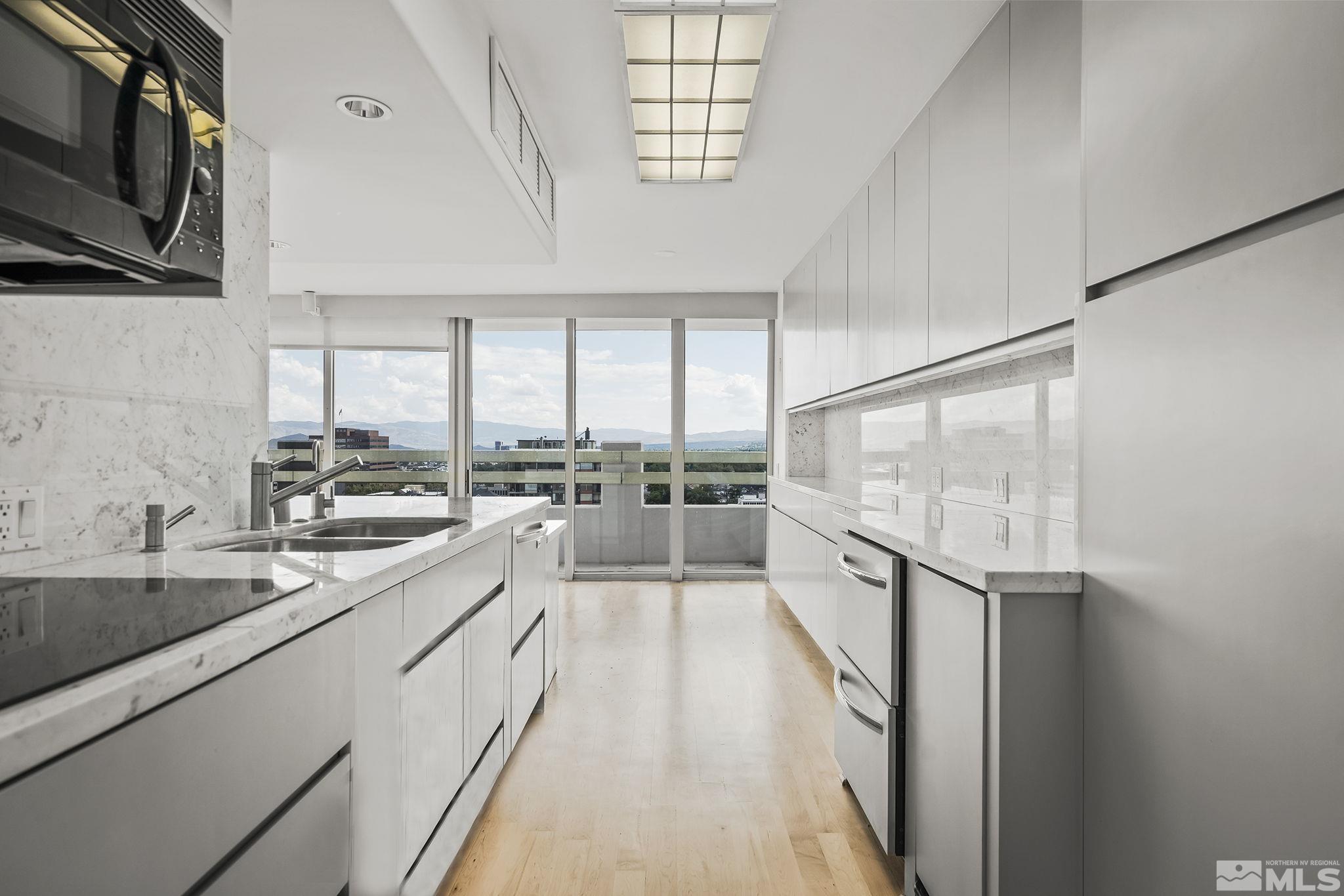 a large white kitchen with a large window
