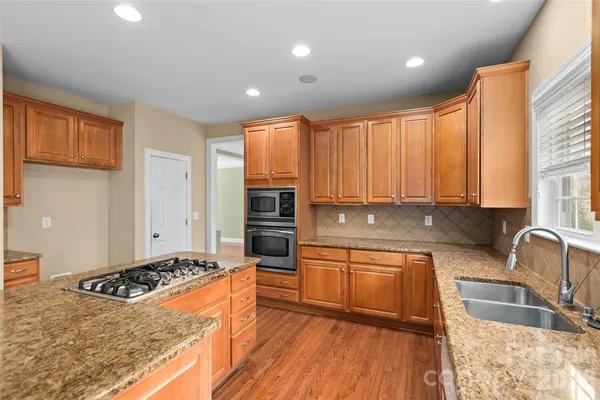 a kitchen with stainless steel appliances granite countertop a stove a sink and a refrigerator