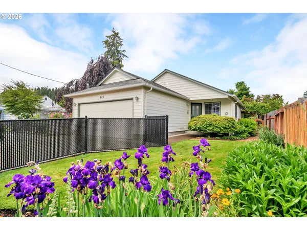 a house view with a lot of flower plants in front of house
