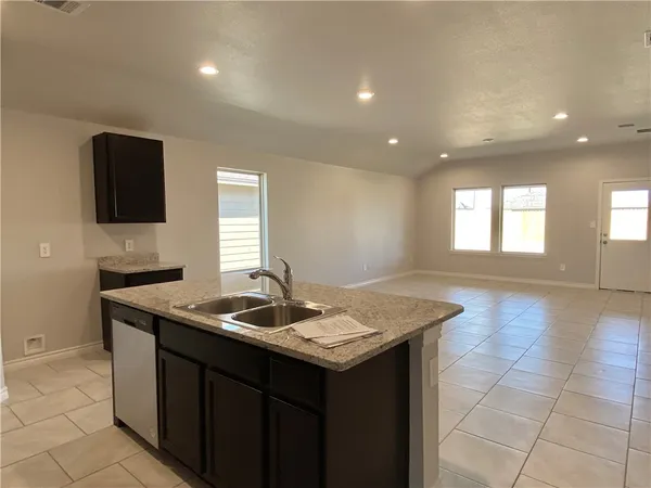 a kitchen that has a sink a microwave oven and a stove in it