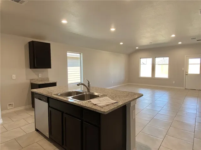 a kitchen that has a sink a microwave oven and a stove in it
