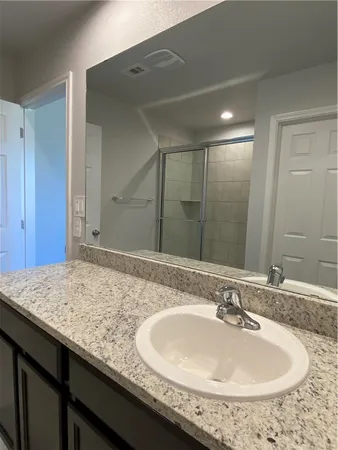 a bathroom with a granite countertop sink and a mirror