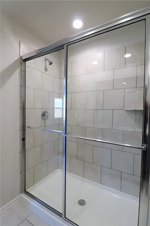 a bathroom with a shower and a glass door