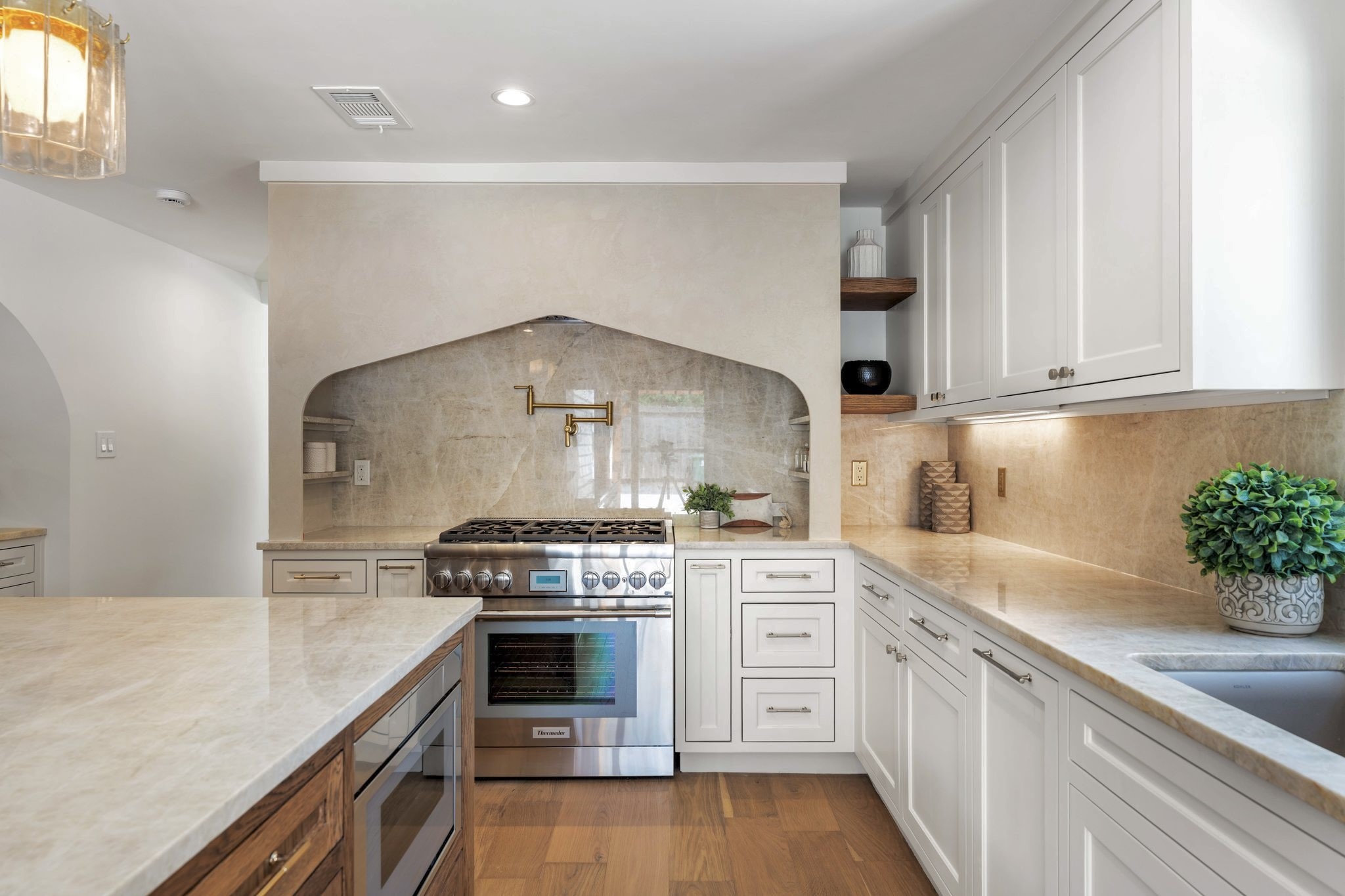 A stunning focal point -the plaster hood and stone backsplash frame the professional range, creating a warm and timeless cooking space.
