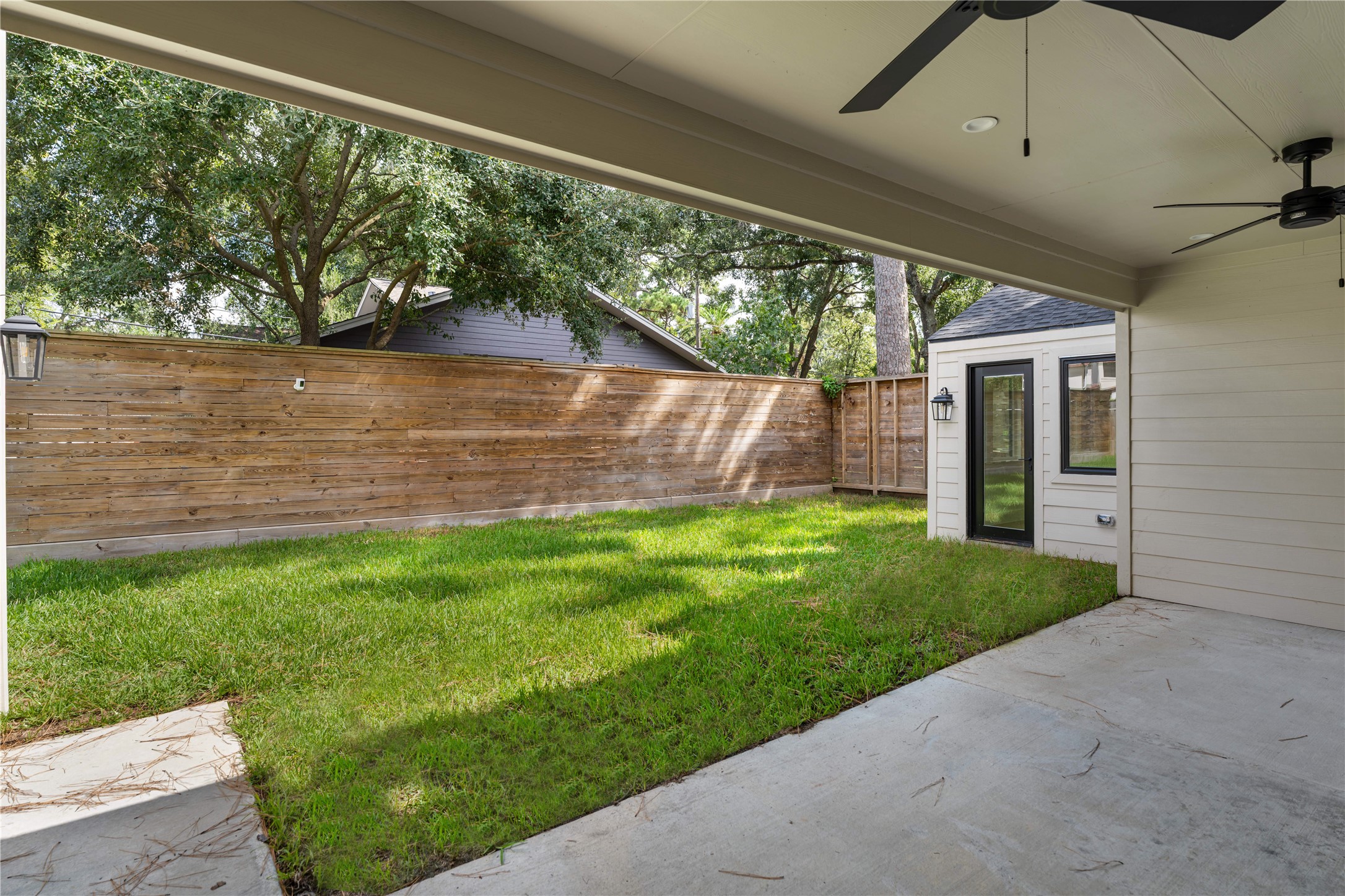 814 Azalea Street Houston, TX 77018 - Photo 27 of 31 Covered patio with dual ceiling fans overlooking a private, fully fenced yard—spacious enough to accommodate a future pool